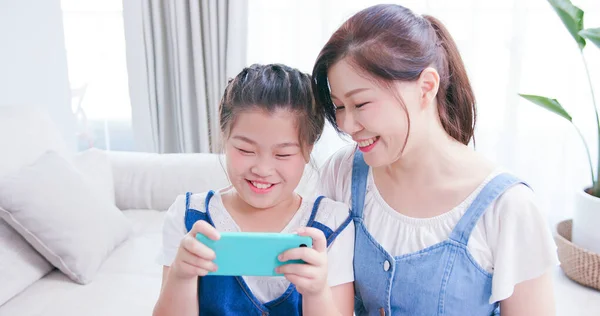 女儿和妈妈使用智能手机和玩游戏快乐 — 图库照片