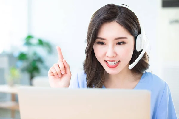 远程工作的概念 亚洲女性使用电脑和耳机话筒参加家庭视频会议 — 图库照片