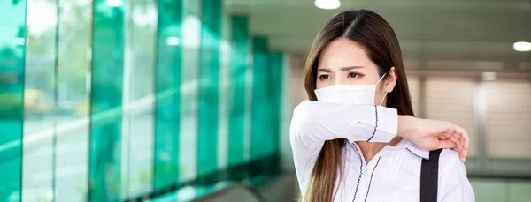 亚洲妇女手肘咳嗽 戴口罩 她在地铁站或火车站上下班 — 图库照片