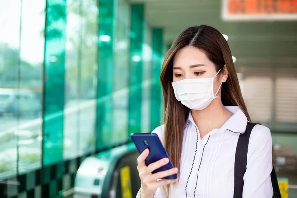 Asiatisk Kvinne Bruker Smarttelefon Mens Hun Går Med Kirurgisk Maskebeskyttelse – stockfoto