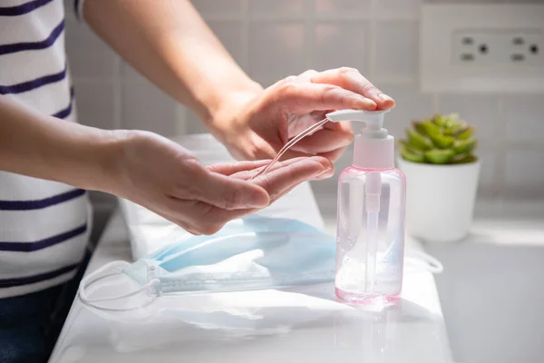 妇女使用清洁剂凝胶 并用酒精或肥皂洗手 以防止病毒通过外科口罩传播 — 图库照片