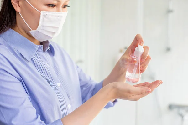 妇女使用清洁剂凝胶 并用酒精或肥皂洗手 以防止病毒通过外科口罩传播 — 图库照片