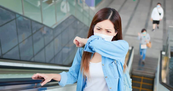 亚洲女人的肘部咳嗽 与其他戴口罩的人保持社交距离 她在地铁或火车站上下班 — 图库照片