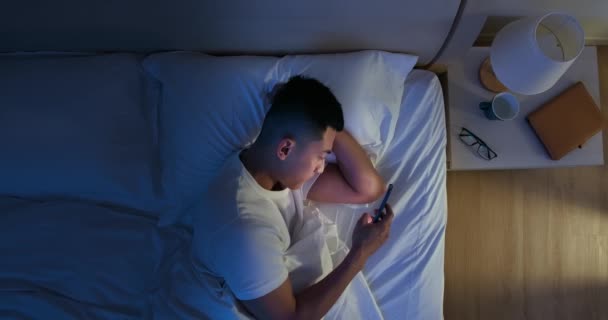 Homem usar smartphone na cama — Vídeo de Stock