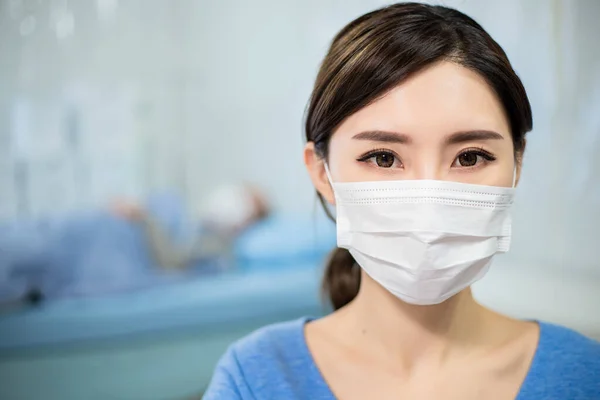 亚洲女人戴着面具看着你 病人躺在病床上 — 图库照片