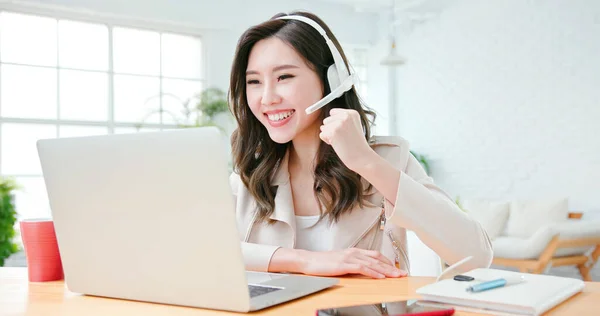 telework concept - Asian woman is very happy to have a good achievement on a video meeting at home