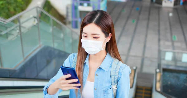 アジアの女性は 地下鉄や鉄道駅で外科マスク顔保護とエレベーターを取りながら スマートフォンを使用しています — ストック写真