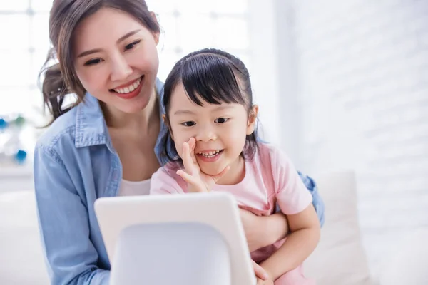 聪明的人工智能说话者的概念 妈妈和女儿愉快地在家里用屏幕和语音助理交谈 — 图库照片