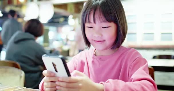 Азиатская девушка счастливо играет в мобильную игру — стоковое видео