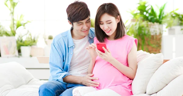 Feliz Casal Grávida Usar Telefone Inteligente Casa — Fotografia de Stock