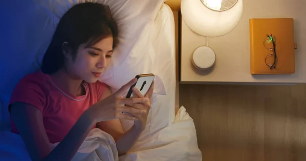 晚上在床上用智能手机看亚洲女人的头像 — 图库照片