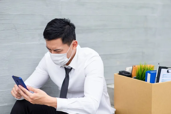 アジアのビジネスマンは顔のマスクを着用し 彼の次の仕事を検索 彼は世界中に広がっているコロナウイルスのために経済的不況のために解雇されています — ストック写真