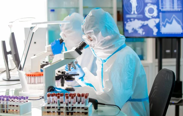 미생물학자 연구가 외톨이 가운이나 보호용 양복을 수술용 마스크를 실험실에서 현미경을 — 스톡 사진