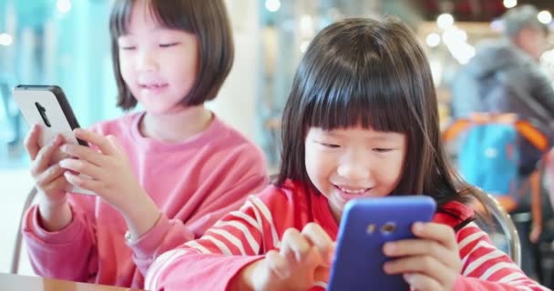 Азиатский ребенок играет на мобильном телефоне — стоковое видео