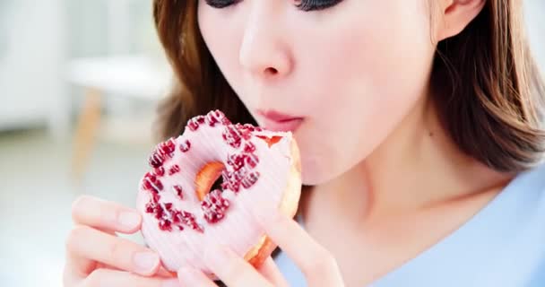 Женщина ест вкусный пончик — стоковое видео