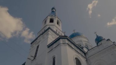 Yüksek beyaz taş kilisenin panoraması mavi taçlarla ve altın haçlarla geniş açılı merceklerle