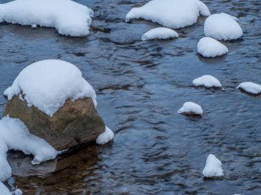 Winter Creek buz ve kar arasında akıyor.