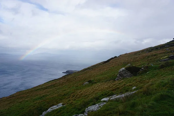 A rainbow behind a hill — Stock Photo, Image