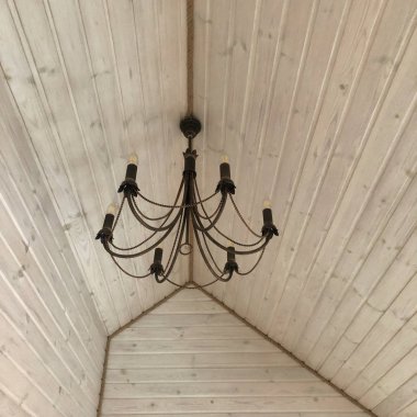 Tavanın altında avizesi olan beyaz ahşap çatı ustası.