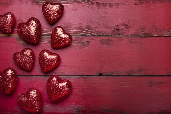 Red Glitter Hartjes Een Rode Houten Achtergrond — Stockfoto