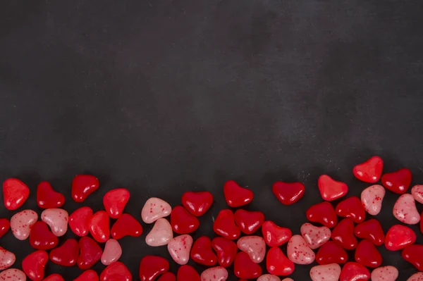 Corazones de caramelo rojo en una pizarra negra —  Fotos de Stock