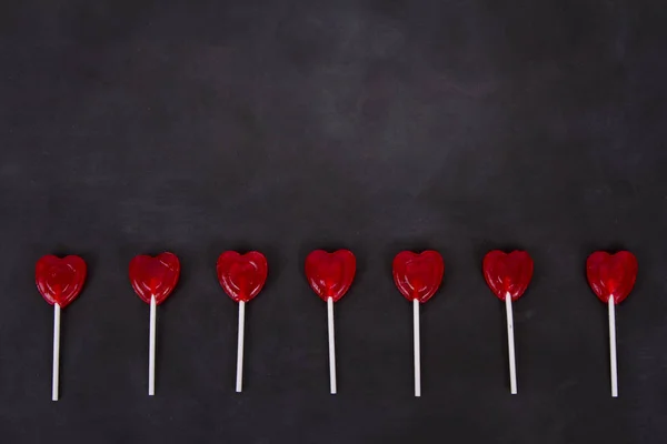 Heart shaped lollipops on a chalkboard — 스톡 사진