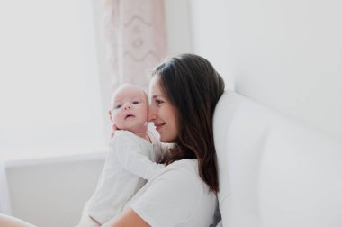 Onun kollarında tutarak bebek için anne gülümser