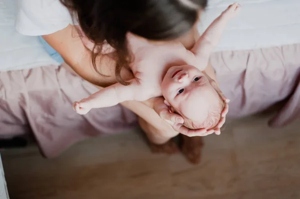 Un petit enfant se trouve dans la mère sur ses genoux et la regarde — Photo