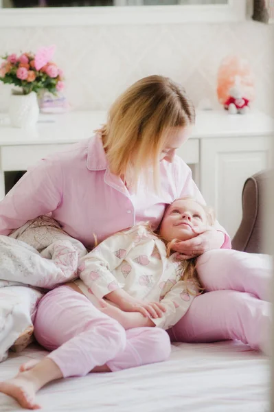 Egy anya gyengéden átfogja a lánya az ágyon Jogdíjmentes Stock Képek