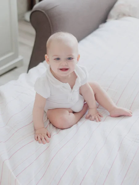 Portrait d'un bébé assis sur un grand lit, style de vie — Photo