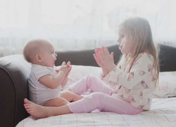 Kleine Schwester spielt mit ihren Händen — Stockfoto