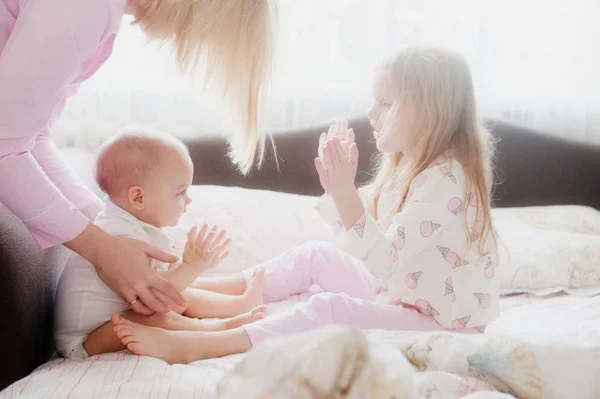 Little sister play on hands in bed — Stock Photo, Image