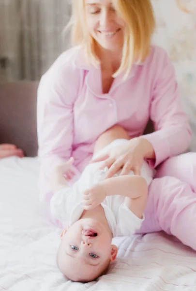 Dziecko bawi się na kolanach Matki w sypialni — Zdjęcie stockowe