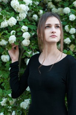 Genç kız çiçek açan bir arka plan üzerinde beyaz kartopu.