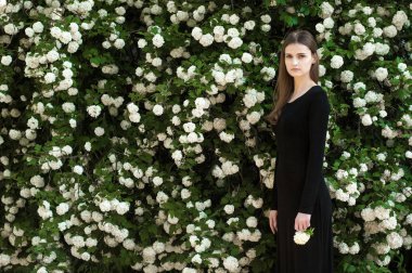 Genç kız çiçek açan bir arka plan üzerinde beyaz kartopu.