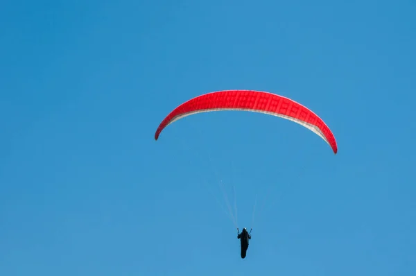 Parapente vermelho voando no céu azul . — Fotografia de Stock