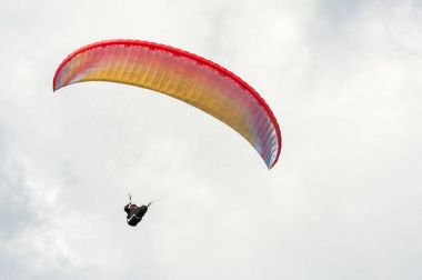 Bulutlar arka planı mavi gökyüzünde uçan Yamaçparaşütü.