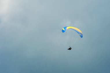 Bulutlar arka planı mavi gökyüzünde uçan Yamaçparaşütü.