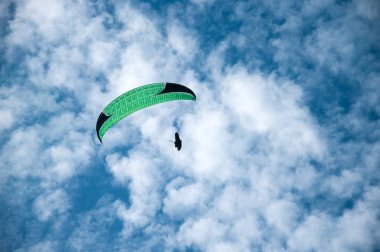 Bulutlar arka planı mavi gökyüzünde uçan Yamaçparaşütü. 