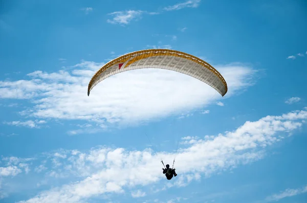 Parapente voando no céu azul contra o fundo das nuvens . — Fotografia de Stock