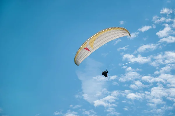 Parapente voando no céu azul contra o fundo das nuvens . — Fotografia de Stock