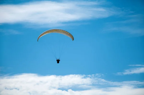 Parapente voando no céu azul contra o fundo das nuvens . — Fotografia de Stock