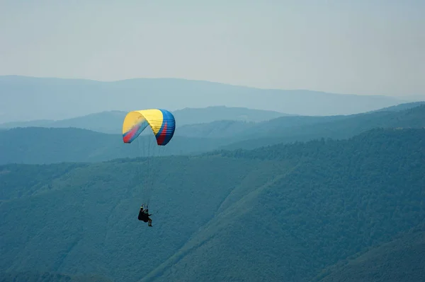 Le tandem survole une vallée de montagne par une journée ensoleillée d'été. Parapente dans les Carpates en été . — Photo