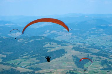 Yamaçparaşütü dağ Vadisi bir güneşli yaz gününde uçar.. 