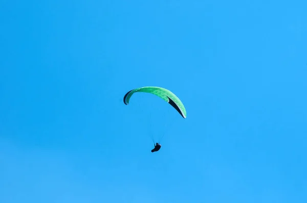 El parapente vuela sobre un valle montañoso en un soleado día de verano . —  Fotos de Stock