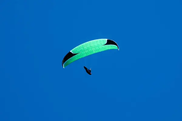 Paraglider flugor över ett berg dalen på en solig sommardag. — Stockfoto