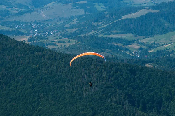 Yamaçparaşütü dağ Vadisi bir güneşli yaz gününde uçar.. 