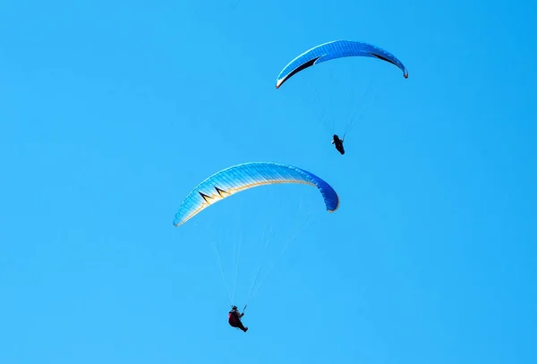 Två paragliders flyger i himlen i soliga dag. — Stockfoto
