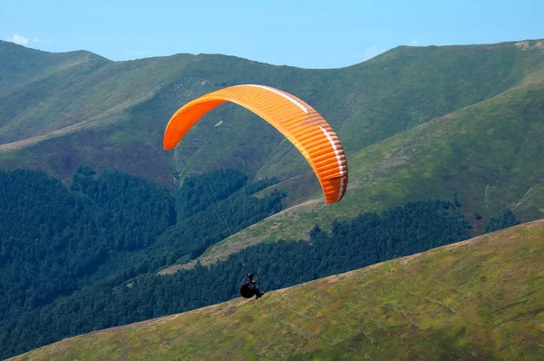One paraglider flies over a mountain valley in summer sunny day in the Carpathians in Ukraine. — Stock Photo, Image