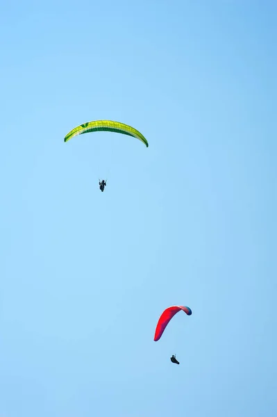 Mavi gökyüzünde uçan iki paraşütler dikey fotoğraf. — Stok fotoğraf